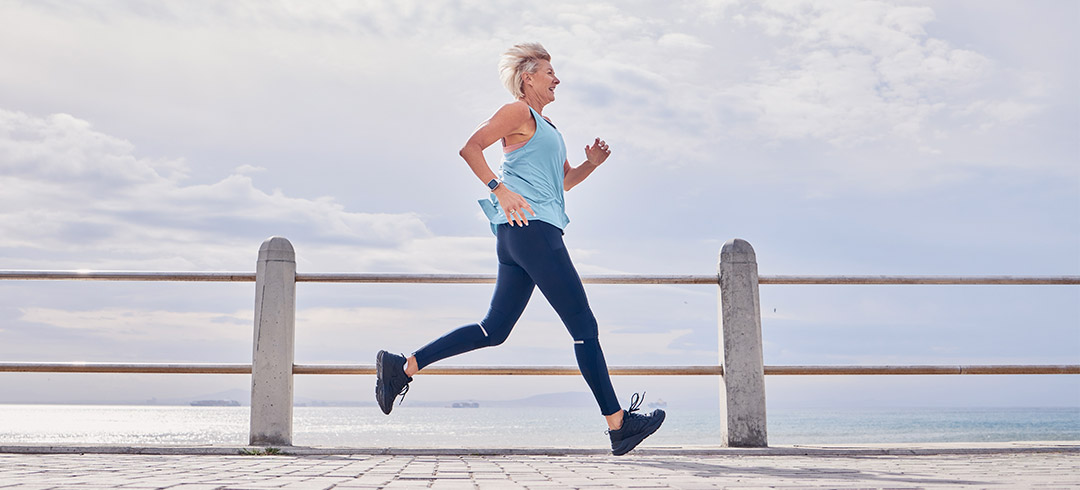 Mujer corriendo por un paseo marítimo