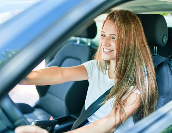 Chica joven conduciendo un coche desde el asiento del conductor
