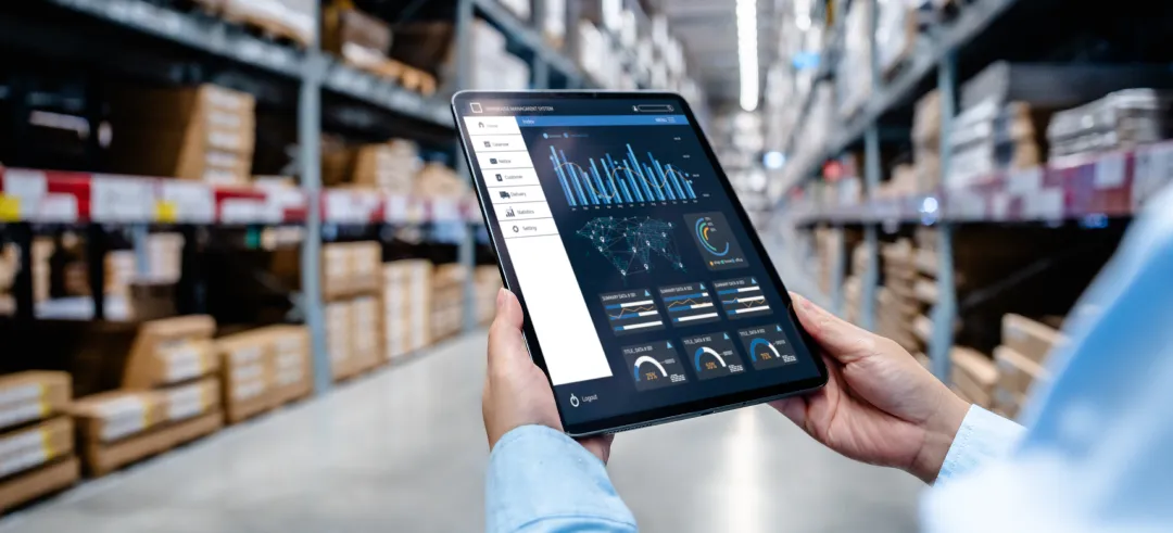 Persona en un almacén sujetando una tablet son gráficos económicos
