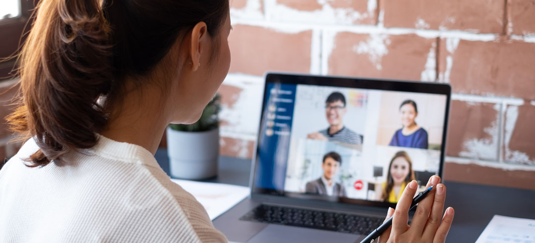 Mujer en una reunión con cuatro compañeros en teletrabajo